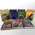 Seven hardcover Harry Potter books displayed, featuring colorful illustrated covers for the complete series.